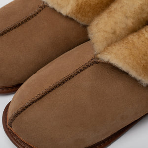 Detail shot of the front 2/3 of a beige Ithaca Sheepskin slipper upper, featuring the top seam, binding, and cuff.